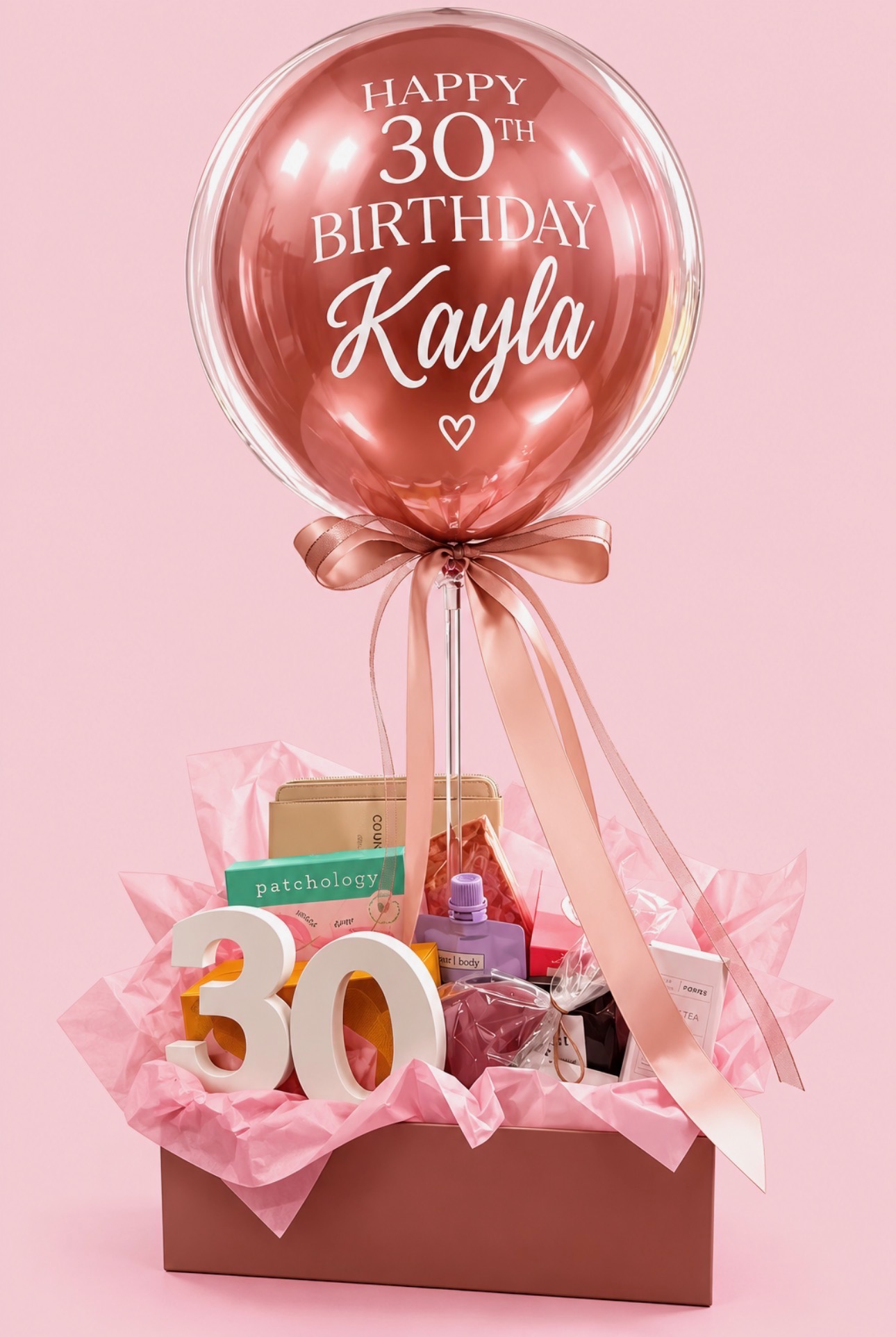Personalised rose gold bubble balloon above a luxury gift hamper